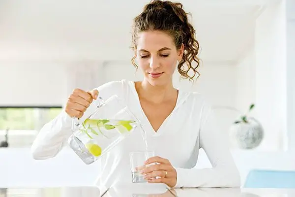 Cách Pha Nước Chanh Buổi Sáng Giảm Cân – Cô Gái Đang Chuẩn Bị Nước Chanh Detox
