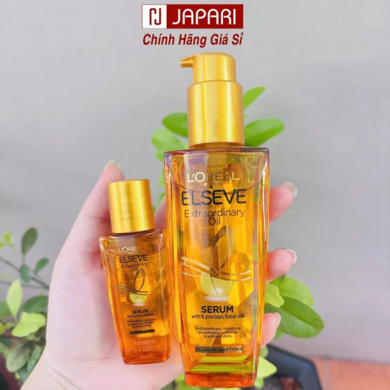 Tay Người Cầm Chai Tinh Dầu Dưỡng Tóc L'Oreal Elseve Màu Vàng Óng Ánh Với Chiết Xuất 6 Loại Hoa Quý.